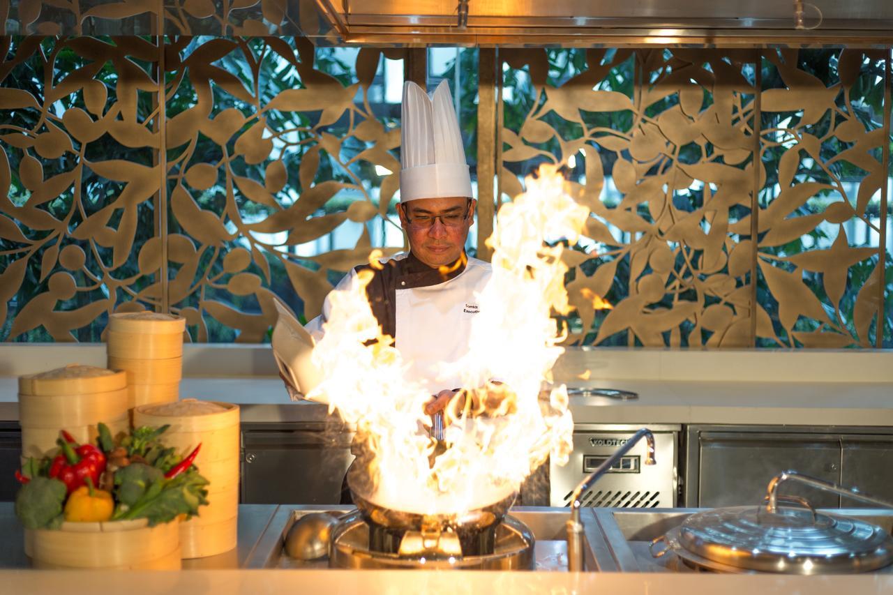 Lancaster Bangkok Hotel Exterior photo A chef flambées a dish
